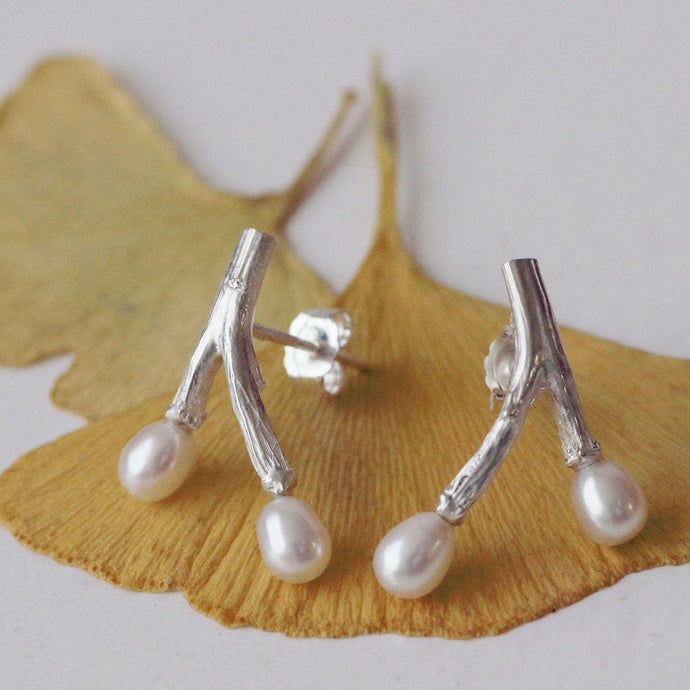 Freshwater pearl earrings, wishbone design twig earrings, placed on dried ginko leaves