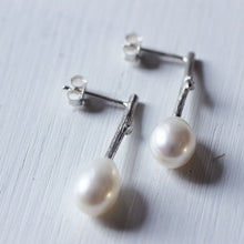 Load image into Gallery viewer, Pearl_drop_earrings-oval_white_pearls laced on a wood white background