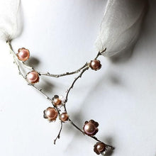 Load image into Gallery viewer, Large silver necklace, pearl flowers and twig statement necklace placed on a white jewelry display bust