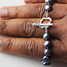 Load image into Gallery viewer, Knotted pearl bracelet closer shot on clasp while placed on fingers and white background