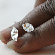 Load image into Gallery viewer, Silver earrings with a natural finish held between fingers on a light background