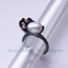 Load image into Gallery viewer, Cocktail ring, black silver, flower and twig designs placed on transparent tube, face view