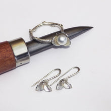 Load image into Gallery viewer, Trillium silver drop earrings for every day paired with a white pearl trillium ring, placed on a burnisher