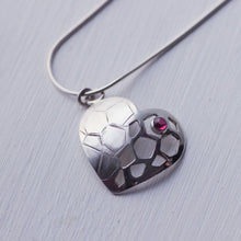Load image into Gallery viewer, Close up shot of sterling silver heart pendant with a red garnet cabochon, white background