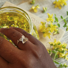 Charger l&#39;image dans la galerie, Black woman hand wearing adjustable flower ring, yellow flowers background
