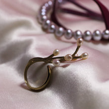 Charger l&#39;image dans la galerie, Vermeil yellow gold ring with twig design placed on satin white fabric, grey pearls and glasses with burgundy frame in the background
