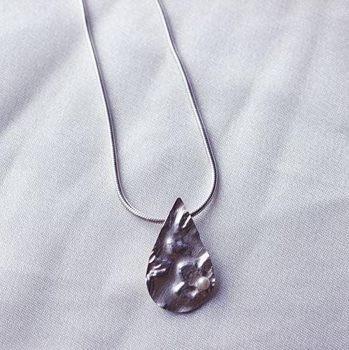 <transcy>Collier goutte en argent massif, motif fleur gravé avec une perle</transcy>