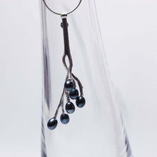 Load image into Gallery viewer, Twig pendant blue pearls placed on a glass pot
