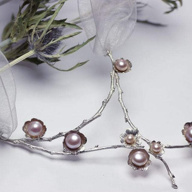 Large silver necklace, pearl flowers and twig statement necklace, floral decor and white background